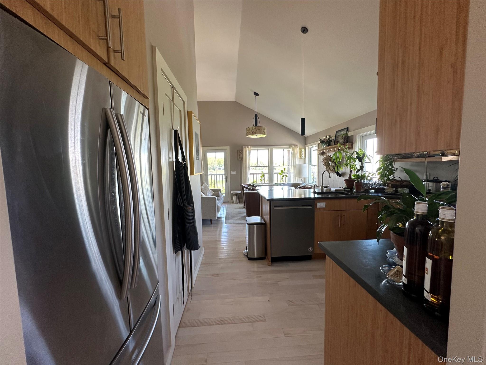 1854 North Bayview Road Southold, NY 11971 - Photo 17 of 20 Kitchen featuring appliances with stainless steel finishes, dark countertops, a peninsula, lofted ceiling, and plenty of natural light