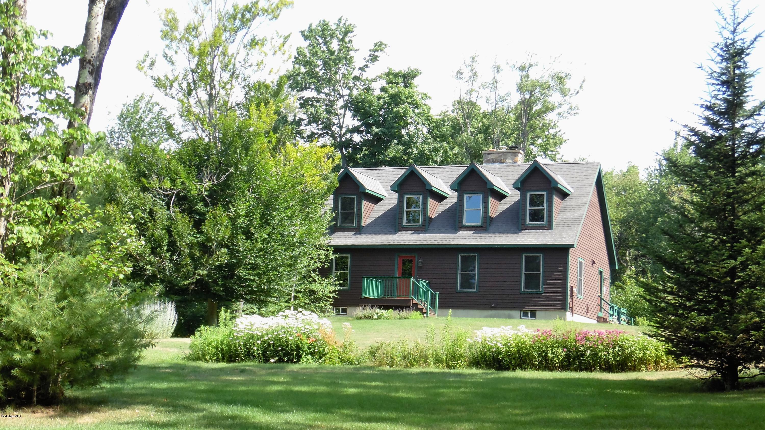 a front view of a house with a yard and trees