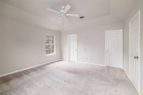 en empty room with windows and ceiling fan