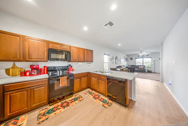 a kitchen with stainless steel appliances granite countertop a sink stove and cabinets