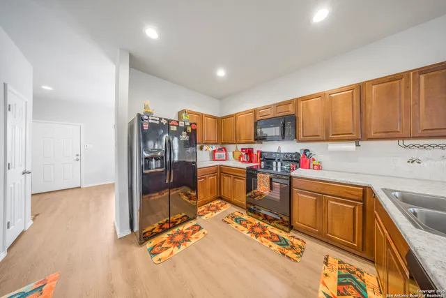 a view of a kitchen with fridge and workspace
