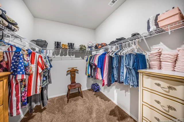 a view of walk in closet with clothes