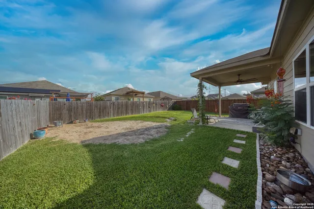a view of a backyard with table and chairs under an umbrella