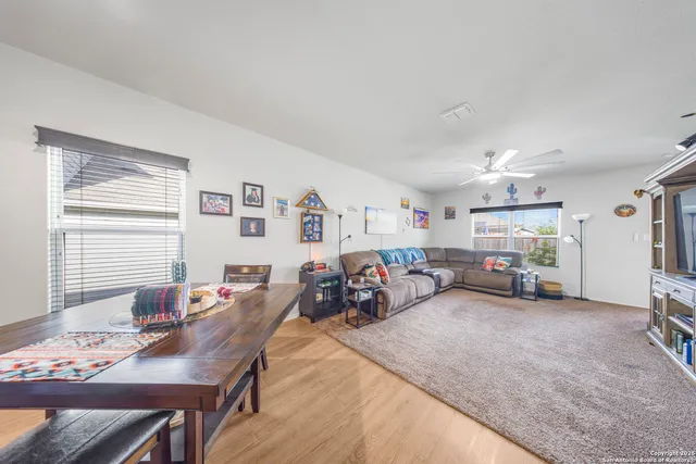 a view of a livingroom and a dining room with furniture window and outside view