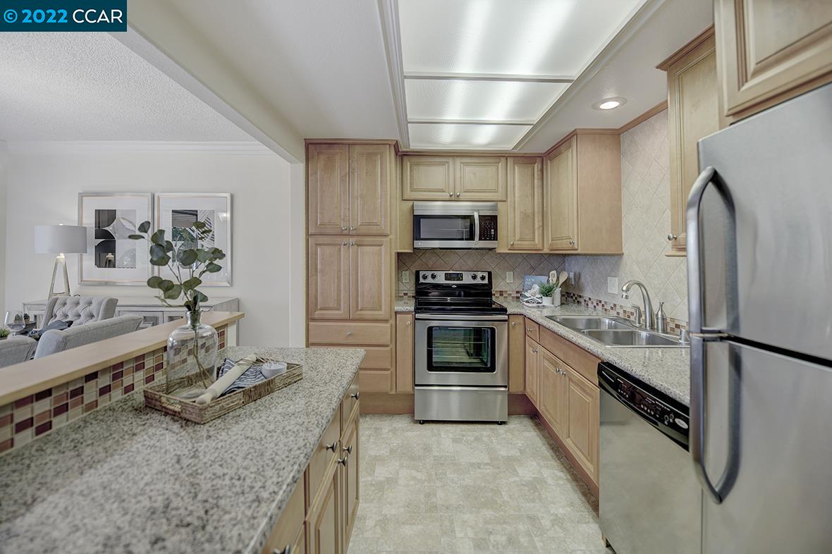 a kitchen with kitchen island granite countertop a refrigerator stove and sink