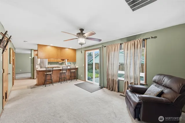 a kitchen with stainless steel appliances granite countertop a table chairs and a refrigerator