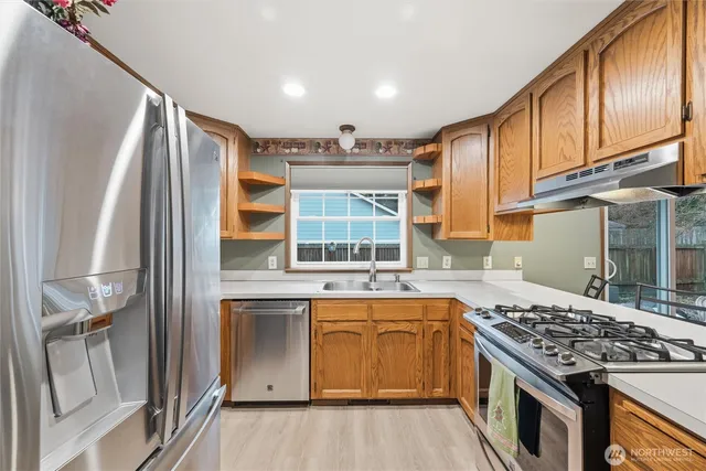 a kitchen with stainless steel appliances granite countertop a stove and a refrigerator