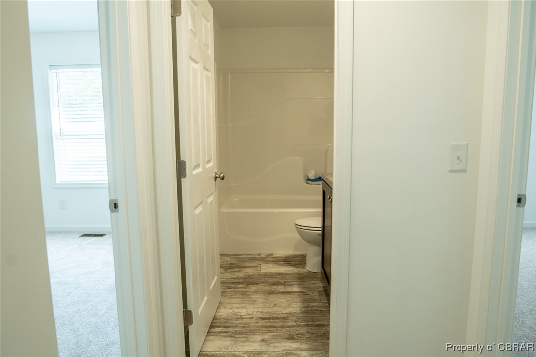 5726 Clay Bank Road Gloucester, VA 23061 - Photo 29 of 40 Bathroom with shower / bath combination, wood-type flooring, and toilet