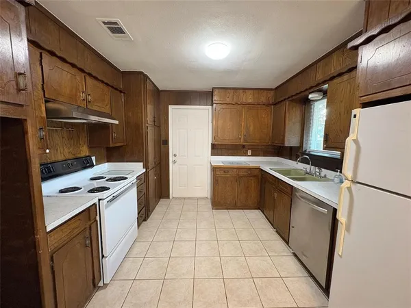 a kitchen with a stove a refrigerator and a sink