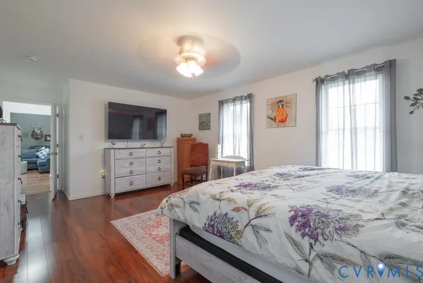 a spacious bedroom with a bed and a flat screen tv