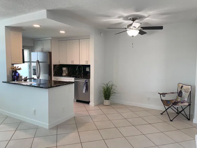 a kitchen with granite countertop white cabinets a sink and appliances