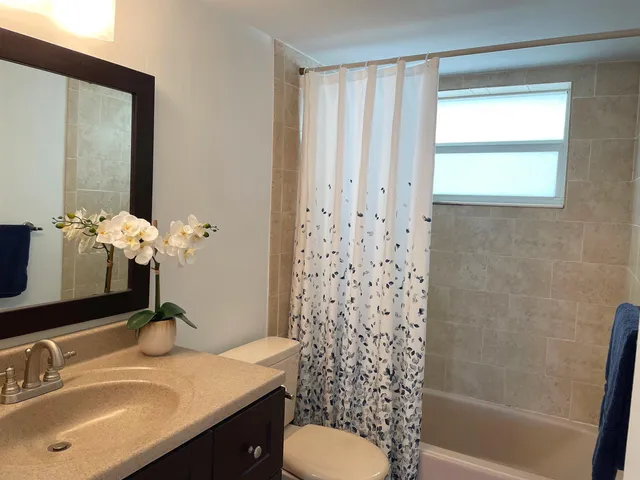 a bathroom with a granite countertop sink toilet and shower