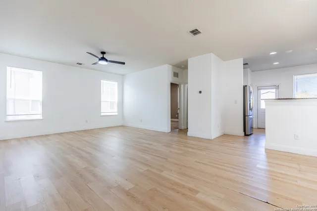 a view of empty room with wooden floor and window