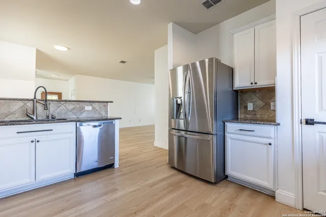 a kitchen with granite countertop a refrigerator and a sink