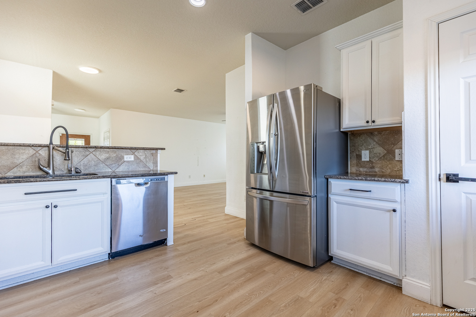 443 Harvest Point Selma, TX 78154 - Photo 9 of 33 a kitchen with granite countertop a refrigerator and a sink