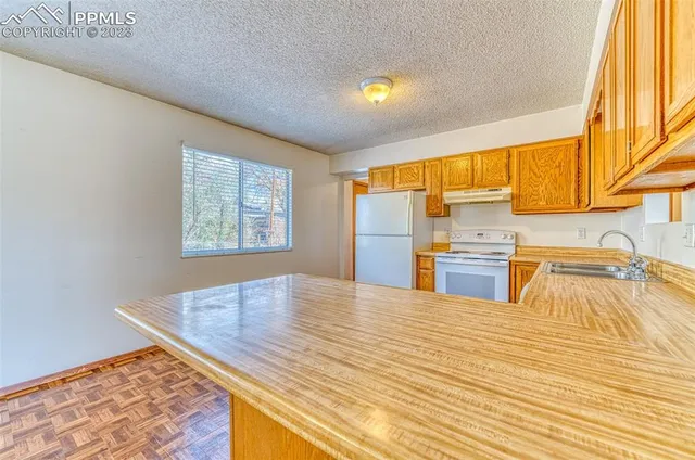 a kitchen with stainless steel appliances kitchen island wooden cabinets and a refrigerator