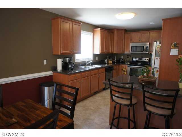 11605 Hillside Road Chester, VA 23831 - Photo 6 of 24 a kitchen with granite countertop a sink cabinets and window