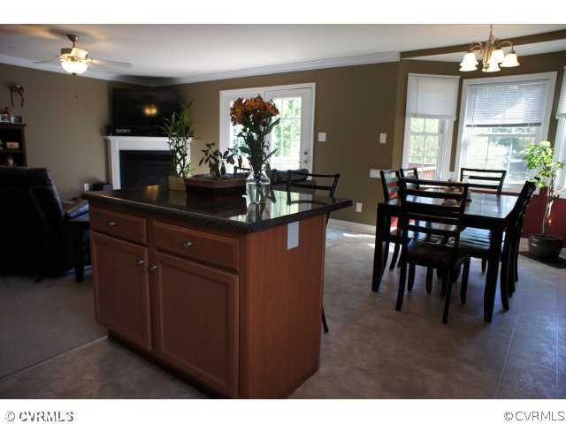 11605 Hillside Road Chester, VA 23831 - Photo 8 of 24 a kitchen with a dining table chairs and fireplace