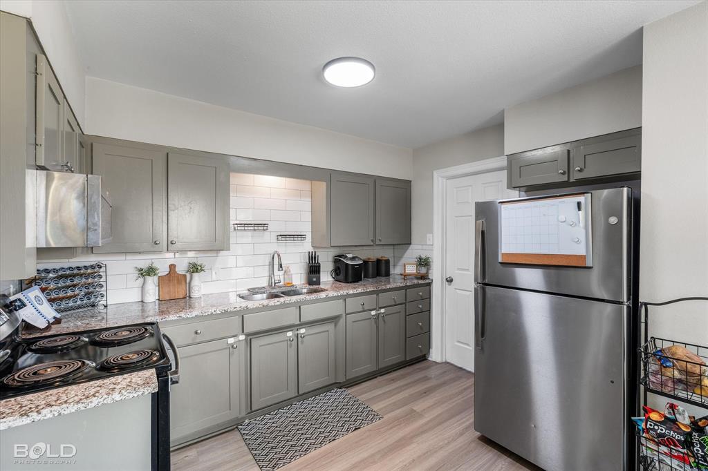 2517 Conrad Street Bossier City, LA 71111 - Photo 24 of 39 a kitchen with a refrigerator a stove a sink cabinets and a wooden floor