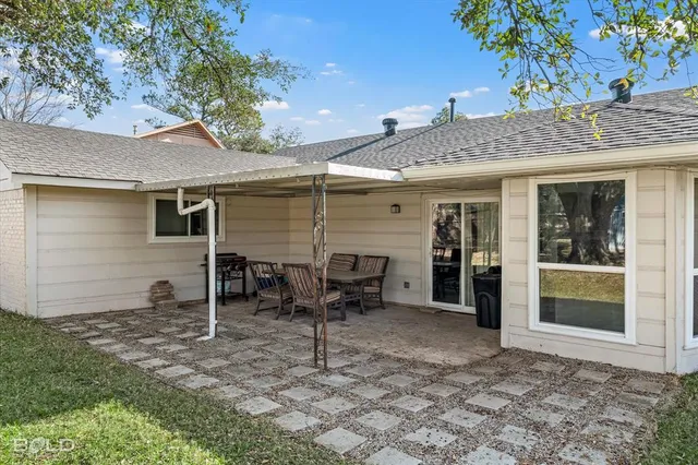 a backyard of a house with table and chairs