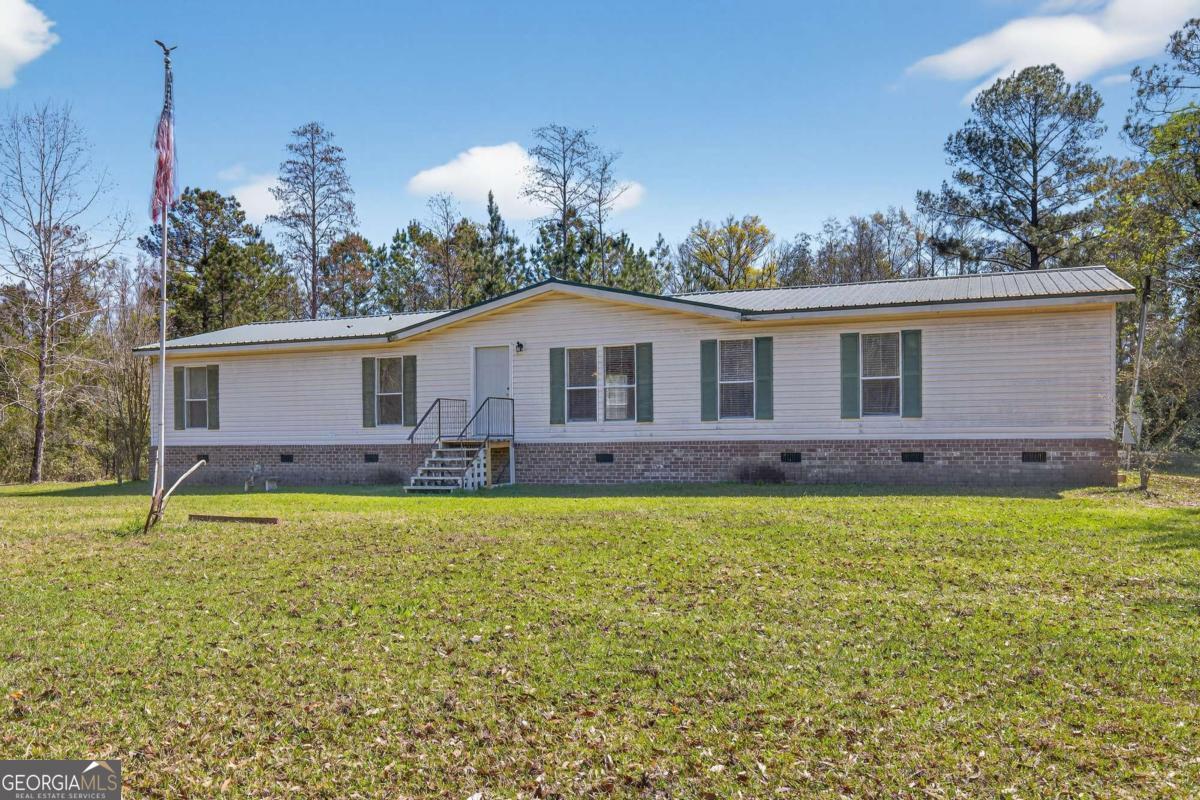 4156 Smiley Road Ludowici, GA 31316 - Photo 1 of 32 a front view of a house with garden
