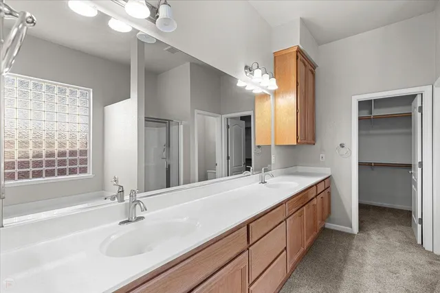 a spacious bathroom with a double vanity sink a mirror and a bathtub