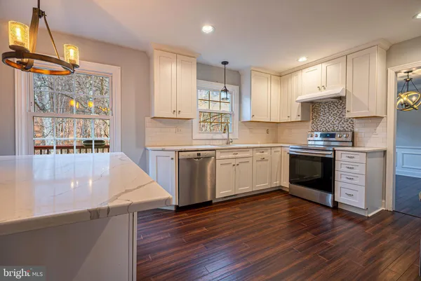 a kitchen with stainless steel appliances a white stove top oven sink and cabinets