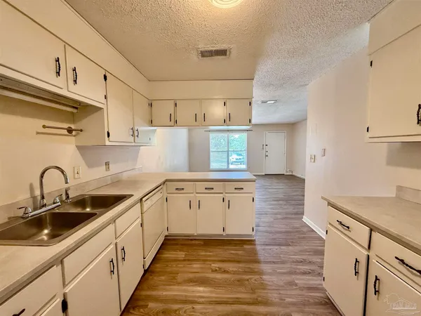 a kitchen with sink a stove and cabinets