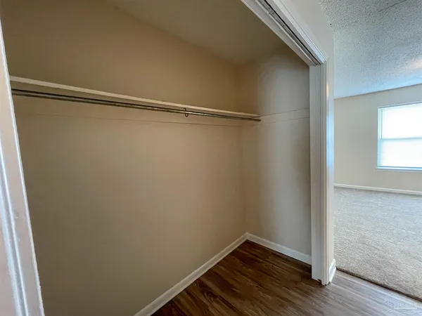 a view of a room with wooden floor and small window