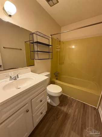 a bathroom with a granite countertop sink a toilet and shower