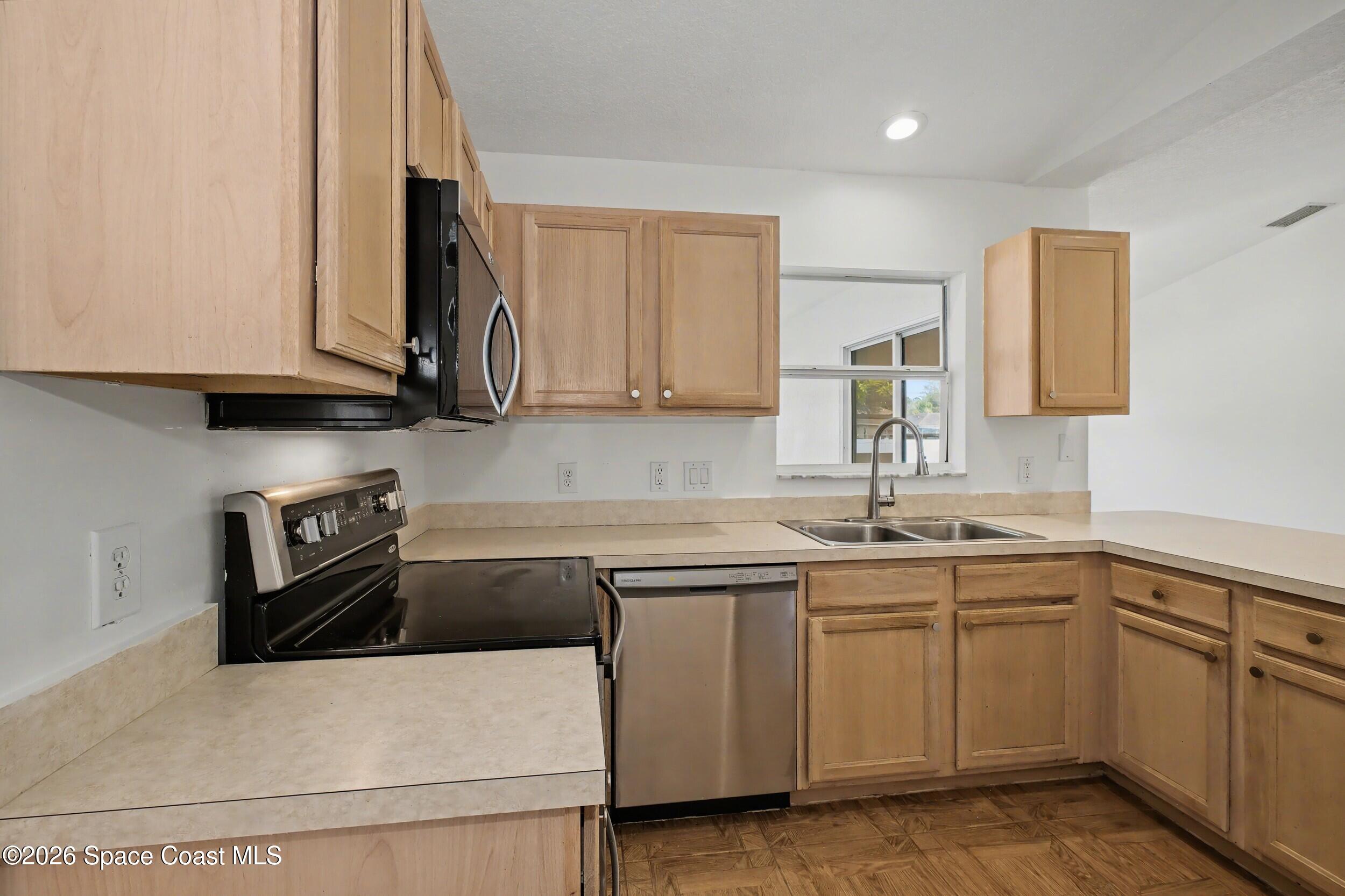 1175 Altamira Street Palm Bay, FL 32907 - Photo 14 of 37 a kitchen with a sink stove and cabinets