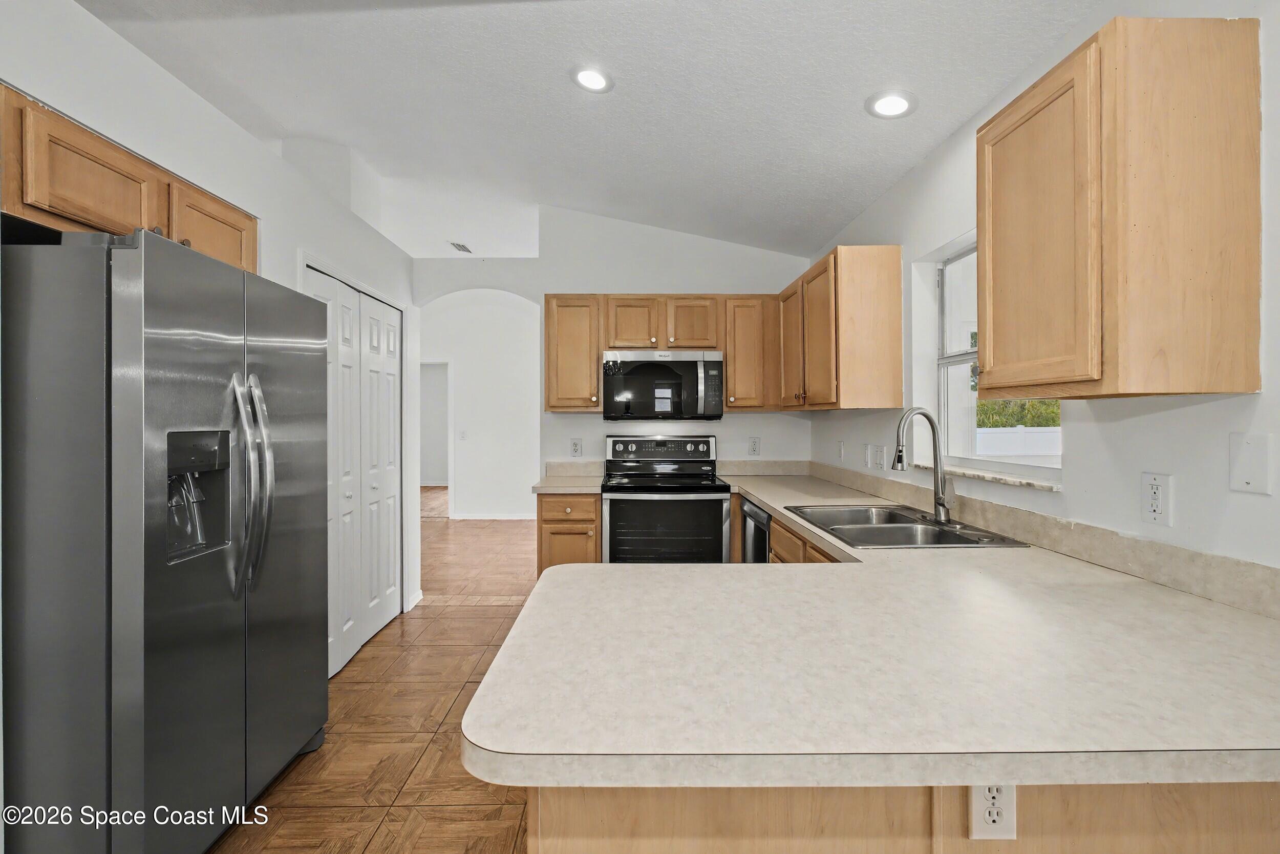 1175 Altamira Street Palm Bay, FL 32907 - Photo 15 of 37 a kitchen with stainless steel appliances granite countertop a refrigerator a stove and a sink