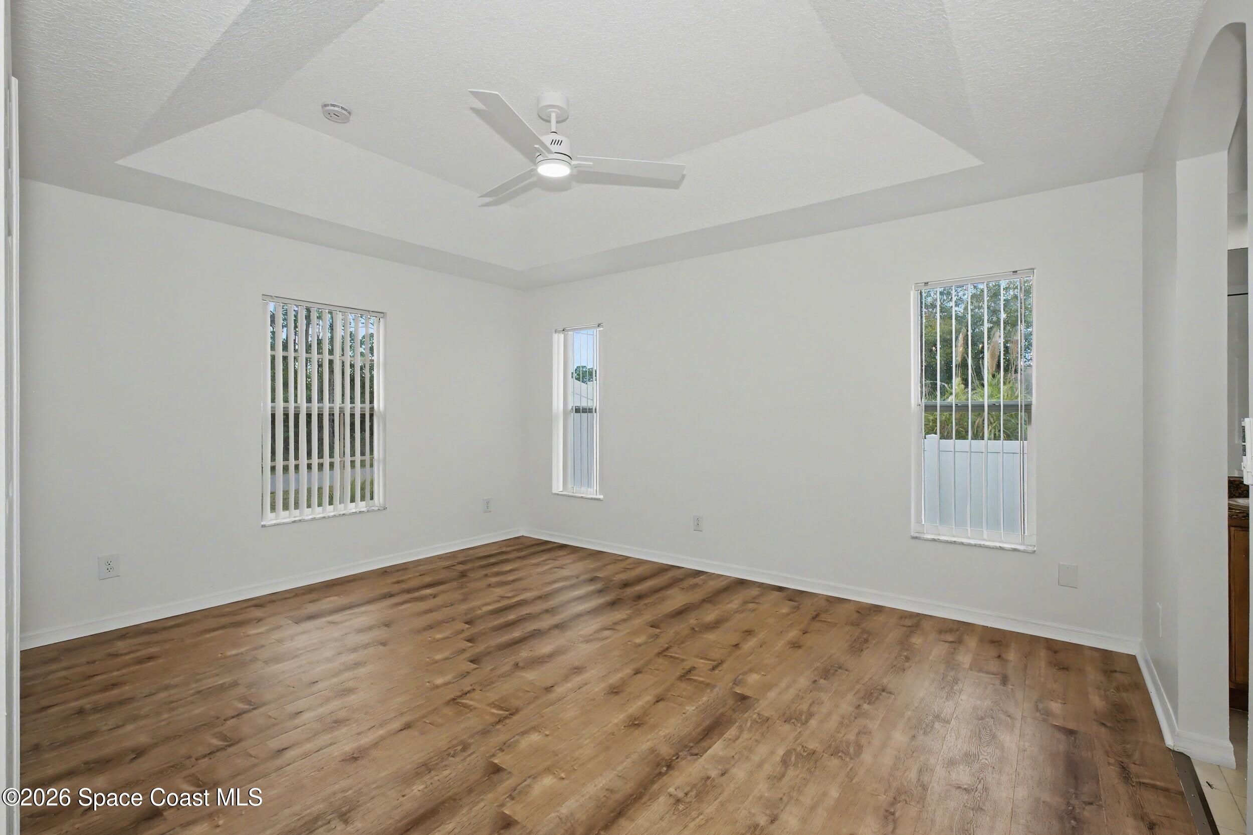 1175 Altamira Street Palm Bay, FL 32907 - Photo 17 of 37 a view of an empty room with wooden floor and a window