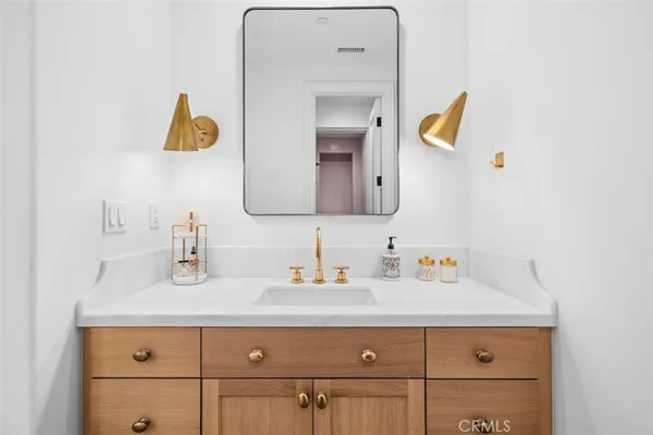 a bathroom with a sink vanity and mirror