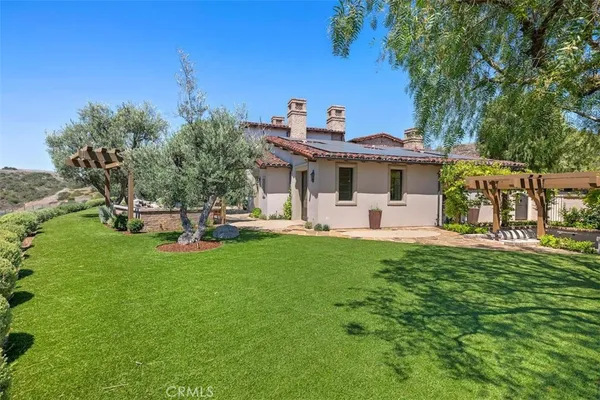 a view of a house with backyard and sitting area