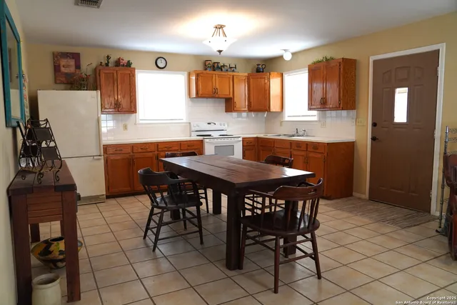 a kitchen with granite countertop a table chairs stove and cabinets