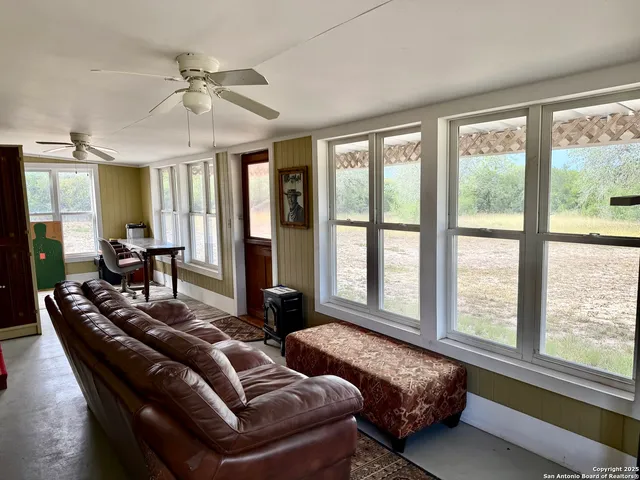 a living room with furniture and large windows