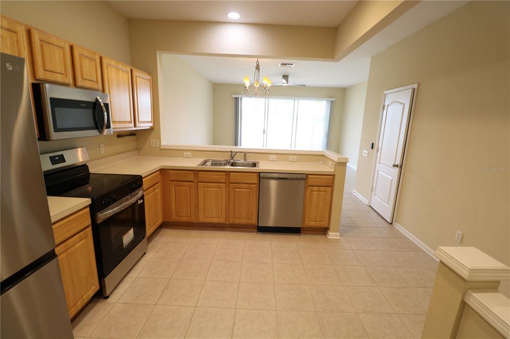 4866 Pond Ridge Drive Riverview, FL 33578 - Photo 13 of 38 a kitchen with stainless steel appliances granite countertop a stove a sink and a microwave