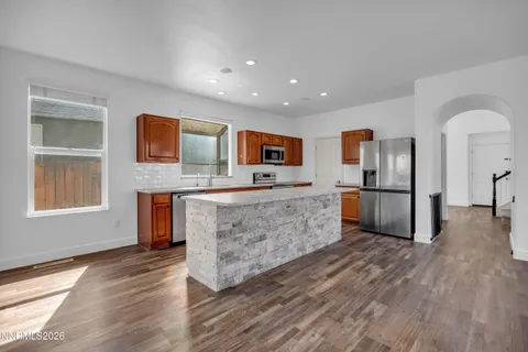 a large kitchen with stainless steel appliances granite countertop a refrigerator and a stove top oven