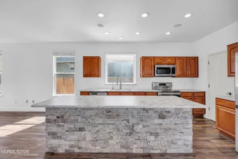 a large kitchen with stainless steel appliances wooden cabinets and a counter top