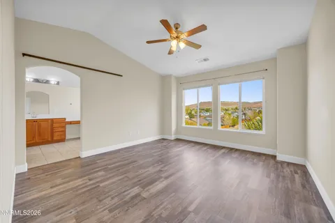 a view of an empty room with a window and wooden floor