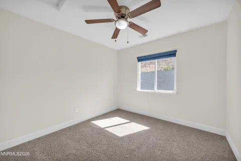 an empty room with a window and a fan