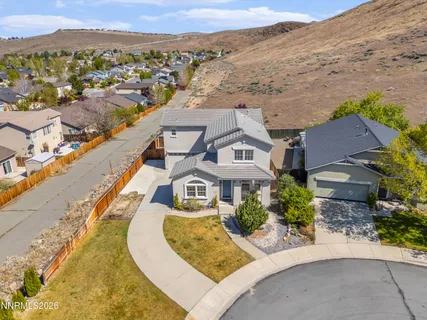 an aerial view of a house with a mountain