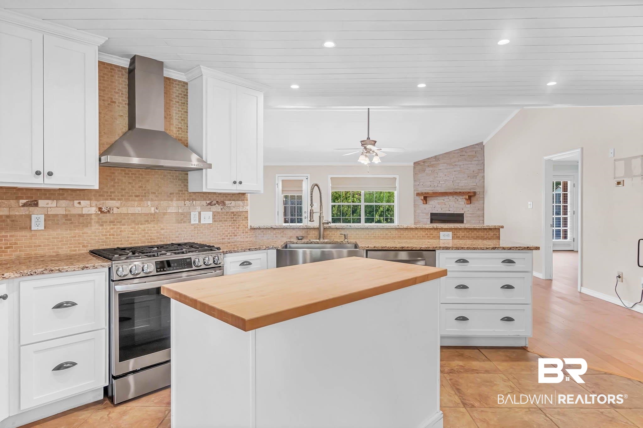 9607 Czar Court Fairhope, AL 36532 - Photo 12 of 42 Kitchen with wooden counters, stainless steel appliances, decorative backsplash, wall chimney exhaust hood, and a peninsula