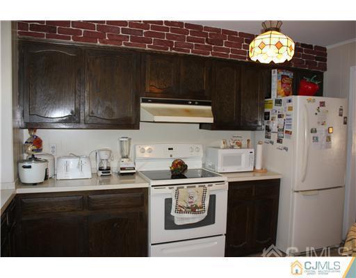 896 Inman Avenue Edison, NJ 08820 - Photo 6 of 14 a kitchen with a sink a stove and refrigerator