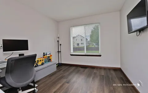 a workspace room with furniture and wooden floor