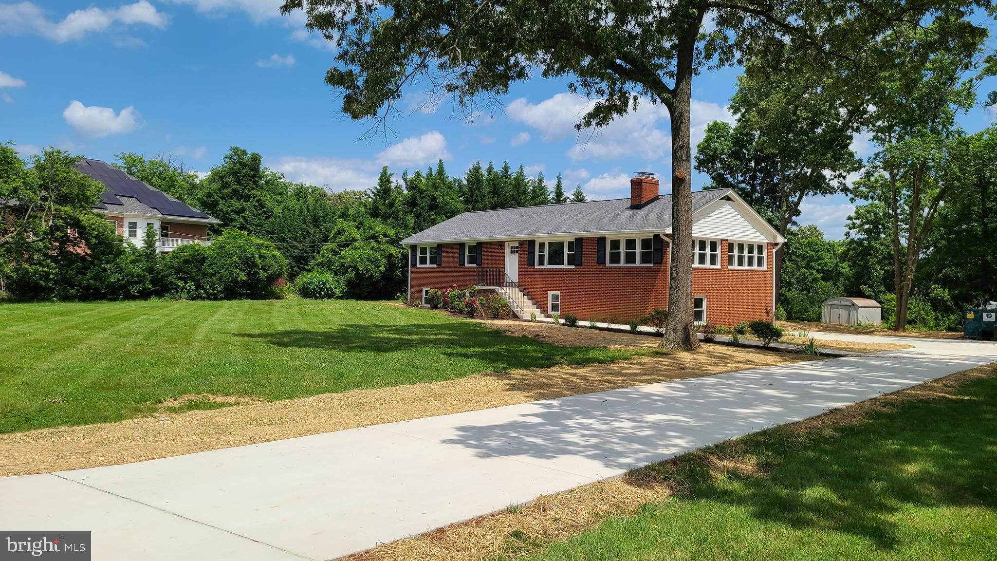 a front view of a house with a yard and green space