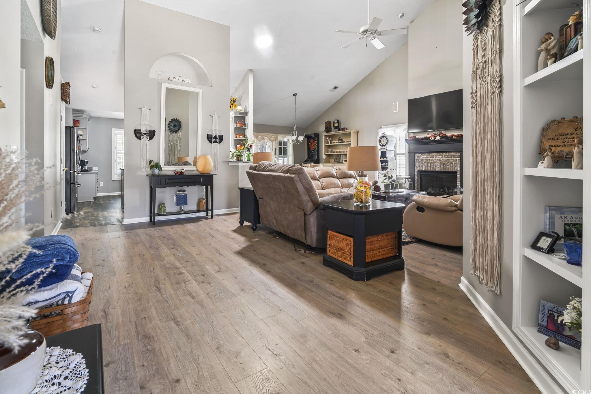 4105 Eva Bay Drive Murrells Inlet, SC 29576 - Photo 12 of 40 Living area featuring built in shelves, high vaulted ceiling, a fireplace, wood finished floors, and a ceiling fan