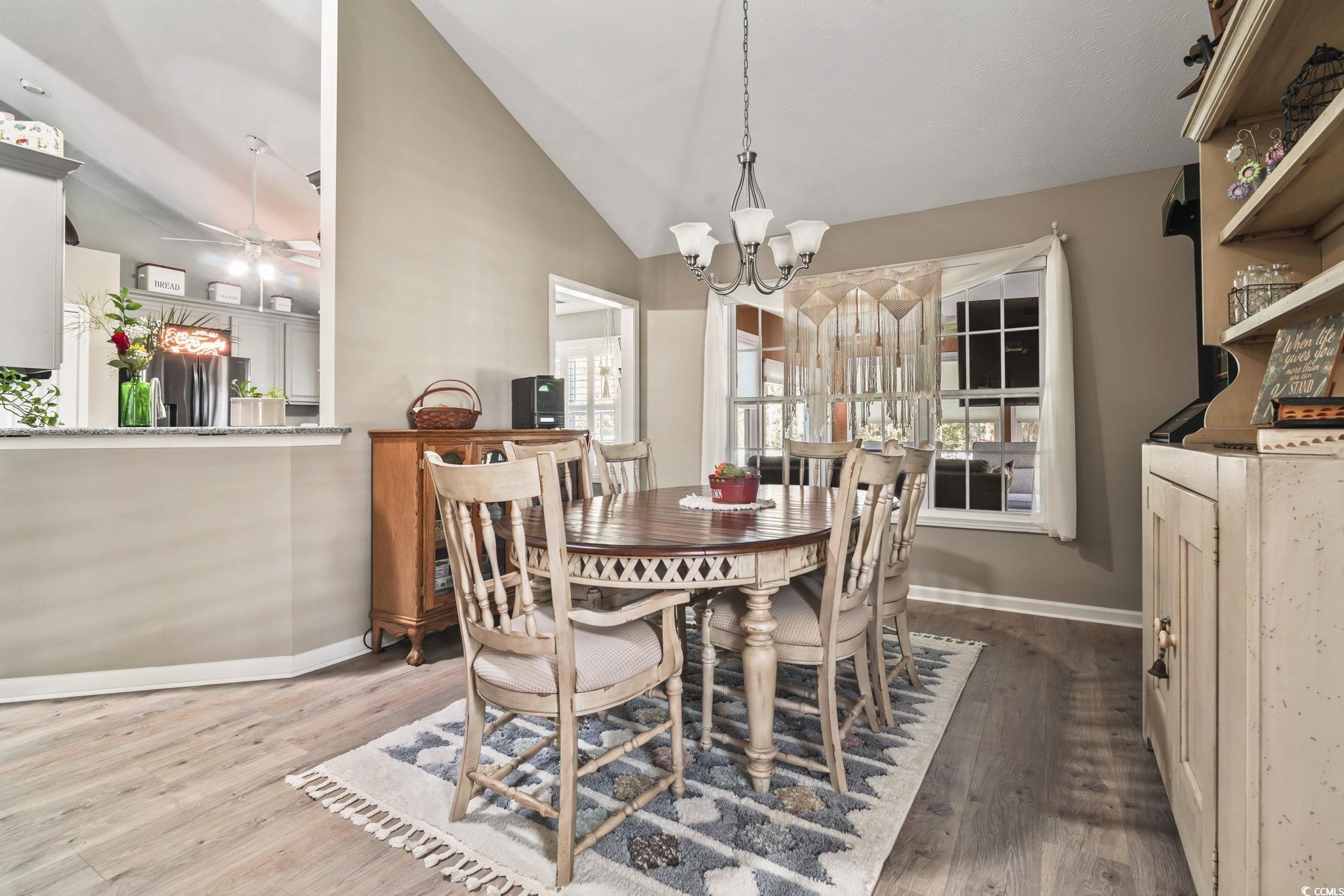 4105 Eva Bay Drive Murrells Inlet, SC 29576 - Photo 14 of 40 Dining space with lofted ceiling, wood finished floors, ceiling fan, and a chandelier