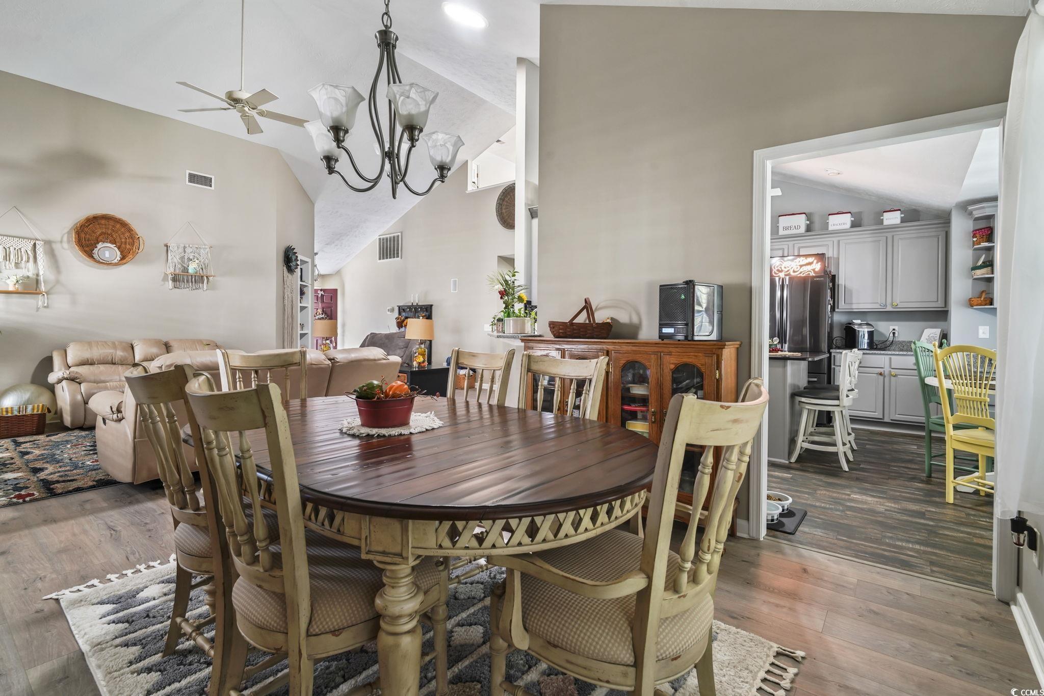4105 Eva Bay Drive Murrells Inlet, SC 29576 - Photo 15 of 40 Dining area with dark wood finished floors, a ceiling fan, high vaulted ceiling, and a chandelier